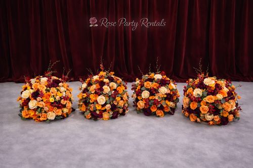 Autumn toned floral arrangements on maroon drape