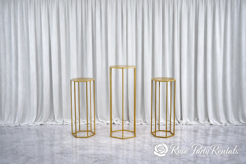 Gold hexagon pedestal stands on white drape